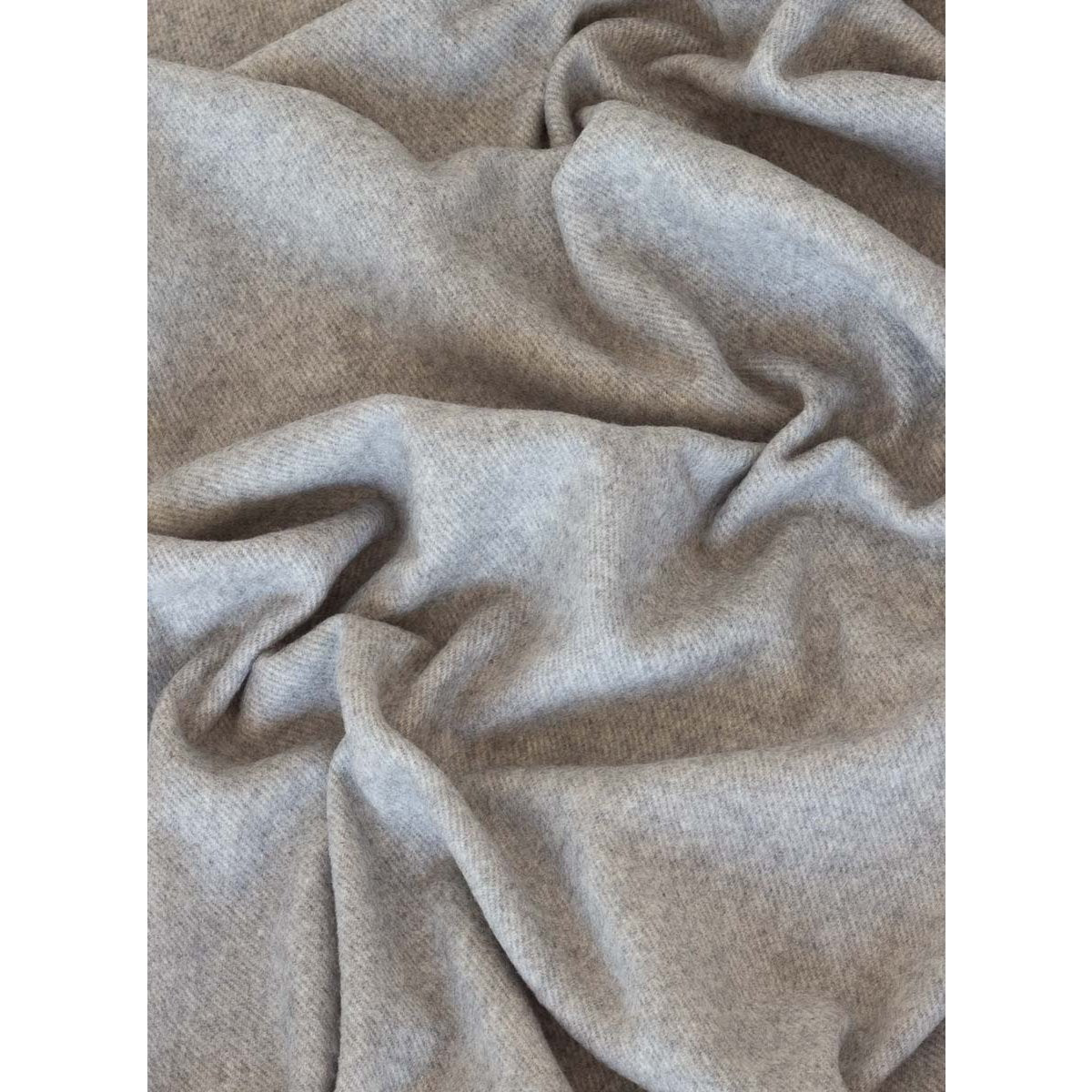 Close-up of beige fabric with folds on a white background