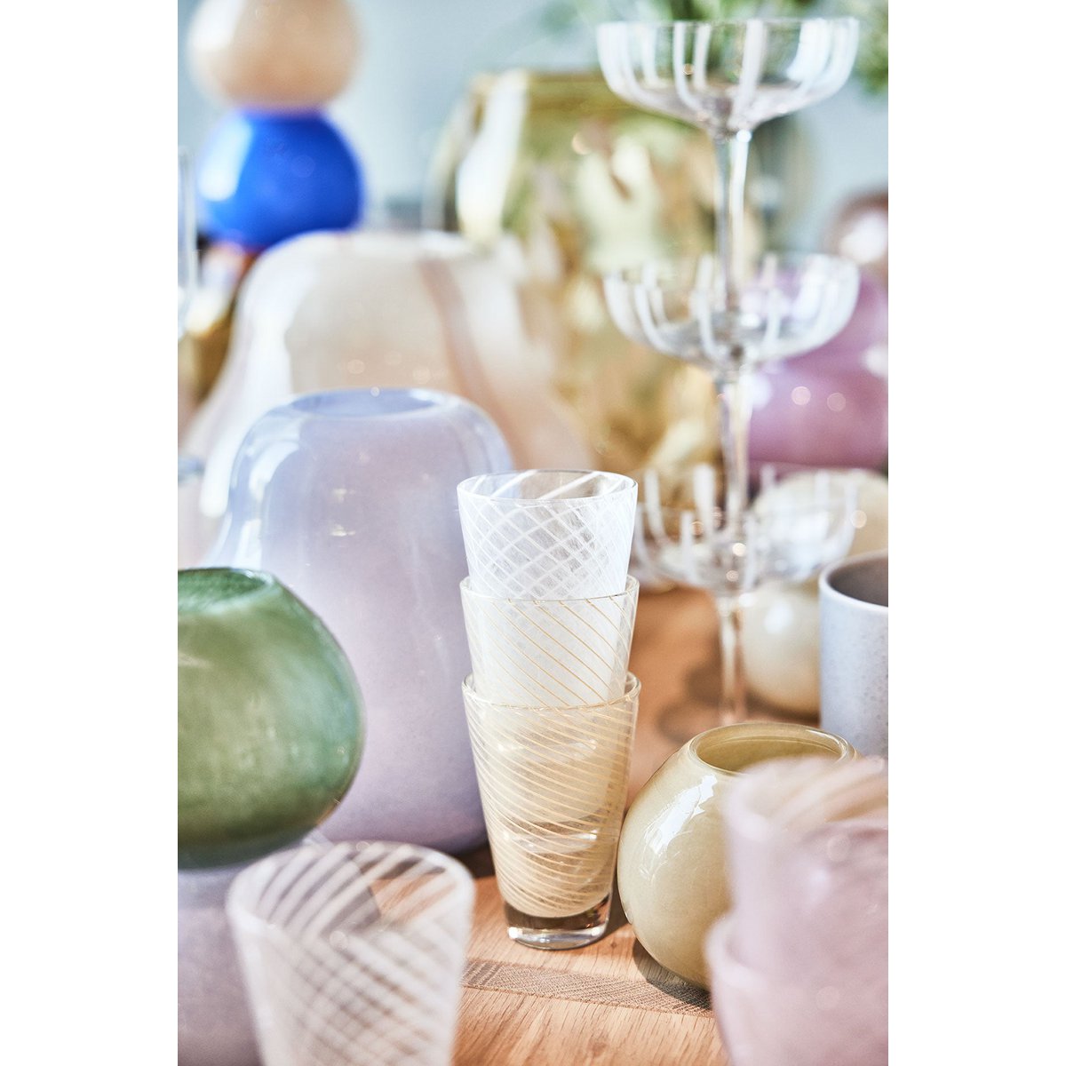 Collection of decorative glasses on a wooden surface with a blurred background