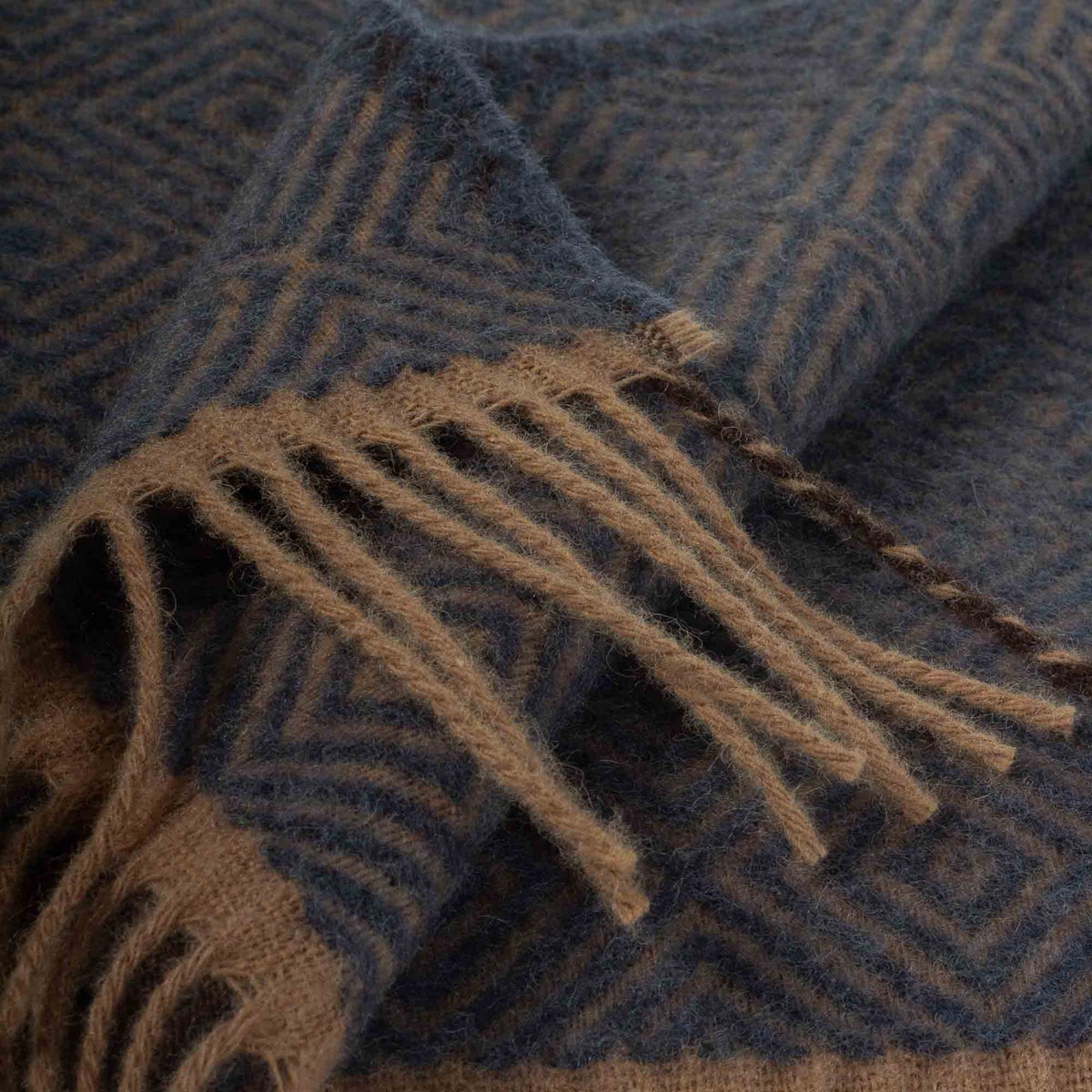 Close-up of a blue and brown patterned fabric with fringes