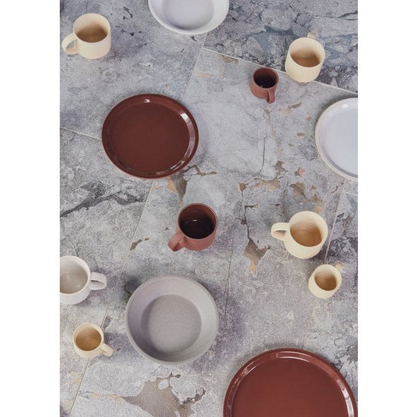 Ceramic plates and mugs on a textured stone surface