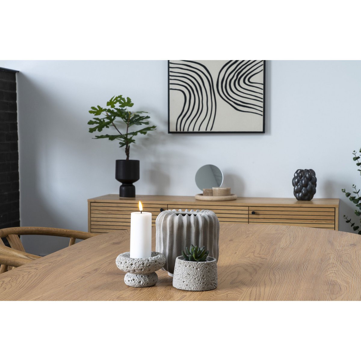 Modern interior with a wooden table, candle, and decorative items.