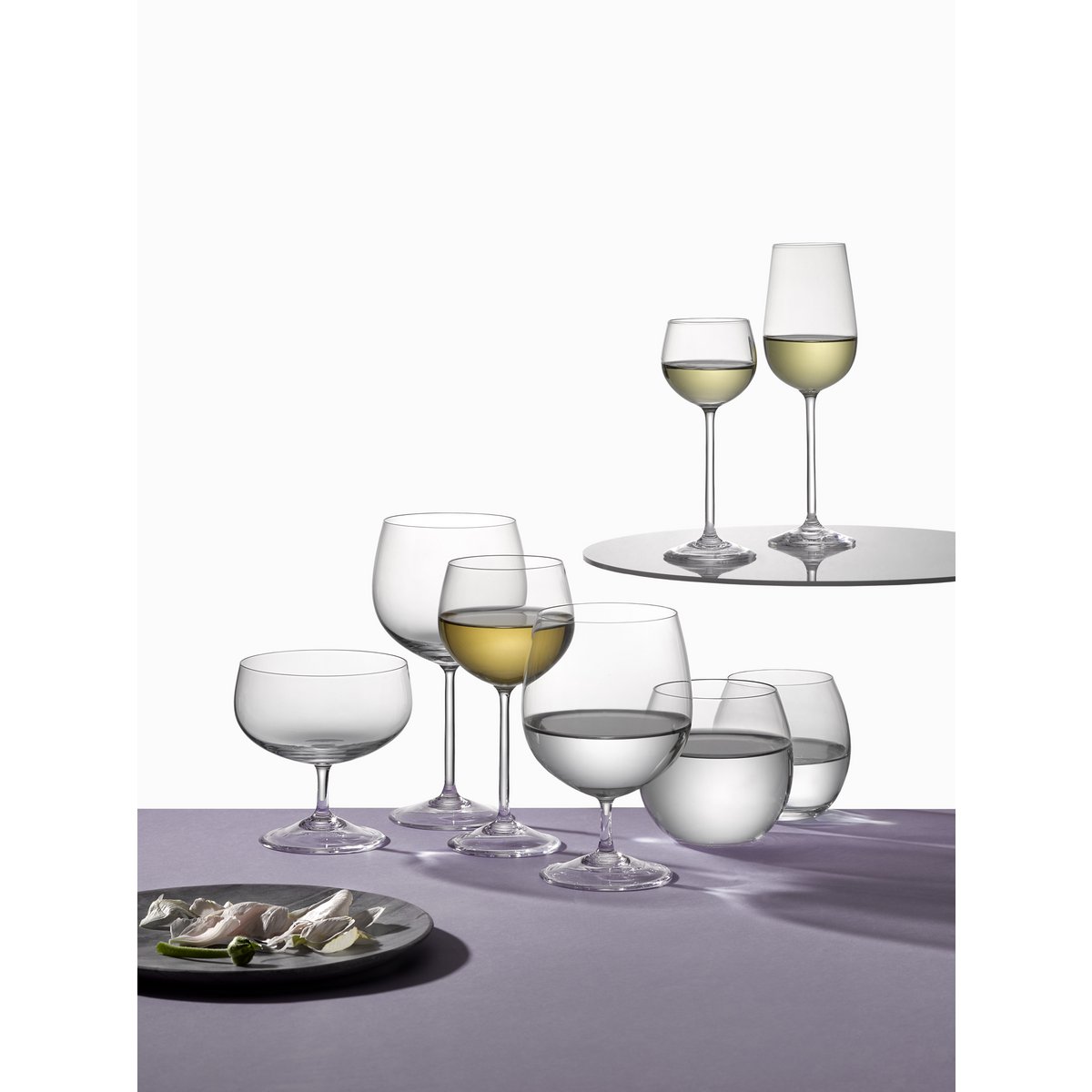 Set of wine glasses with white wine on a white background