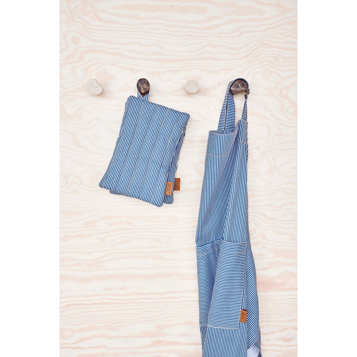Blue striped apron and pouch hanging on a wooden surface