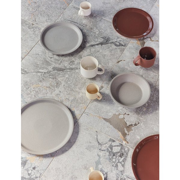 Ceramic plates and mugs on a marble surface