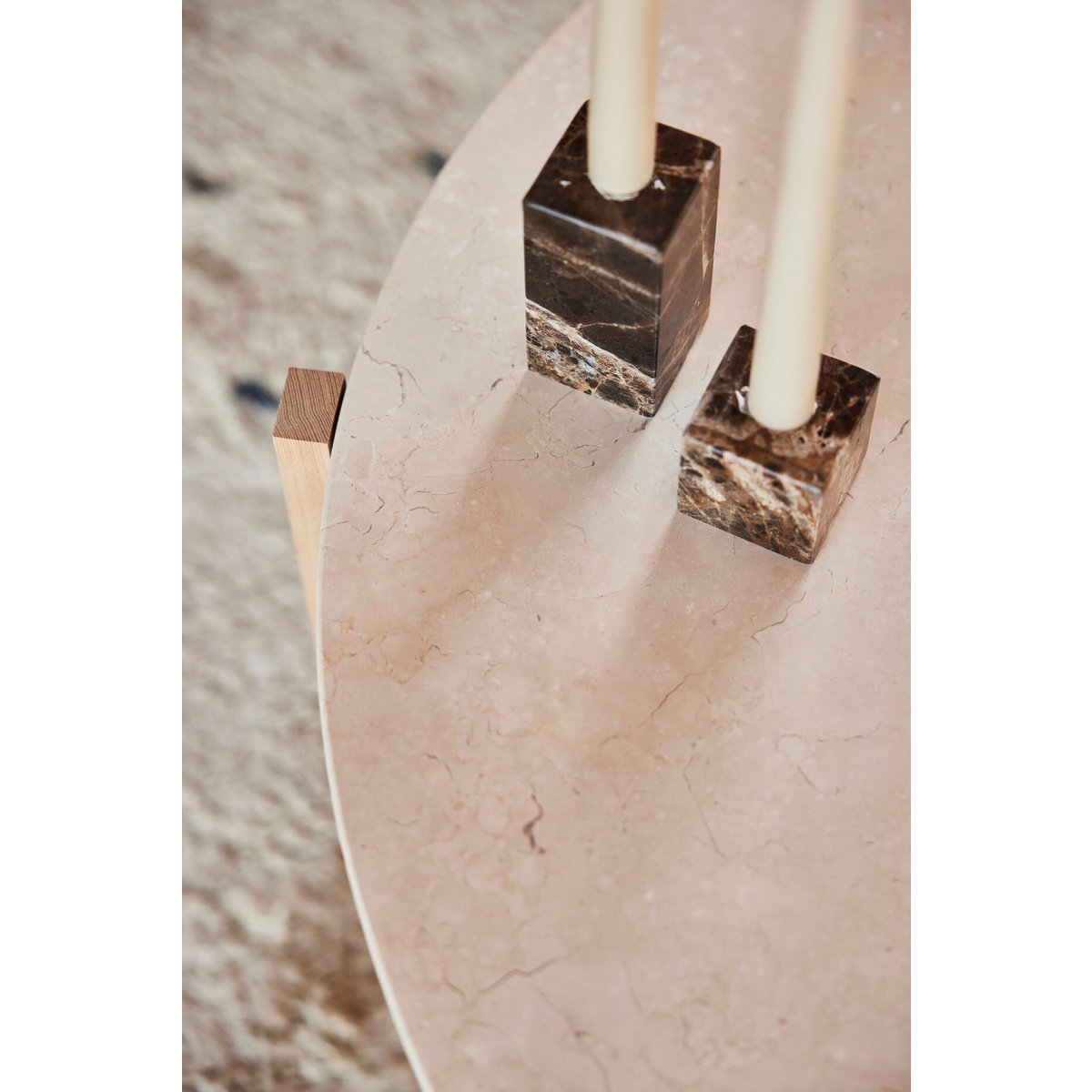 Marble candle holder with square bases on a textured surface