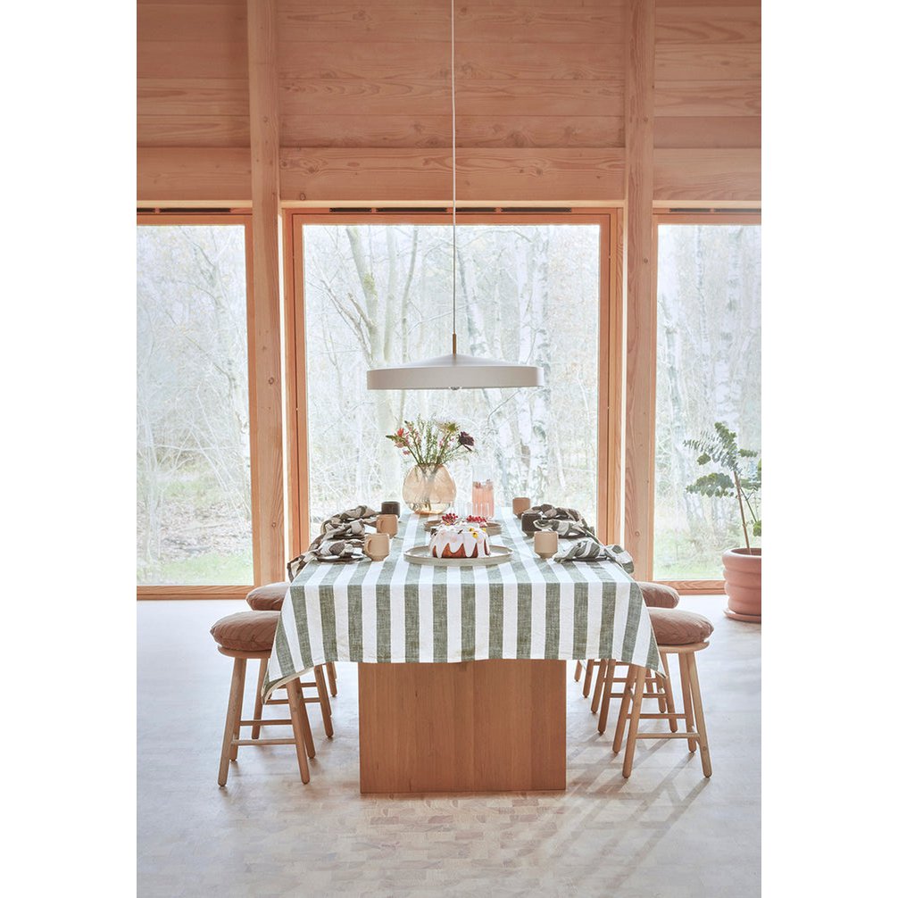 Dining area with a table set for a meal in a room with large windows.