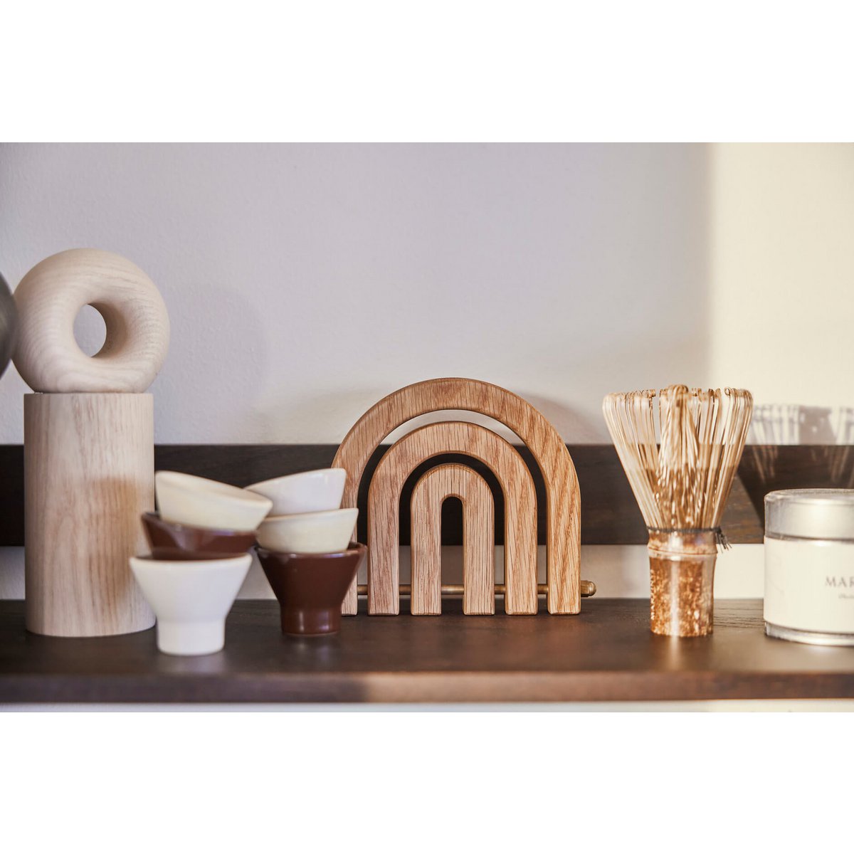 Collection of wooden and ceramic items on a shelf with a neutral background