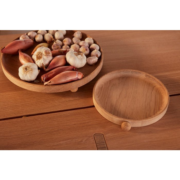 Wooden trays with garlic and shallots on a wooden surface