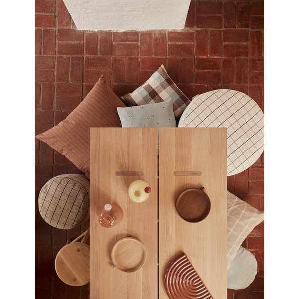 Wooden table with decorative items against a red brick wall