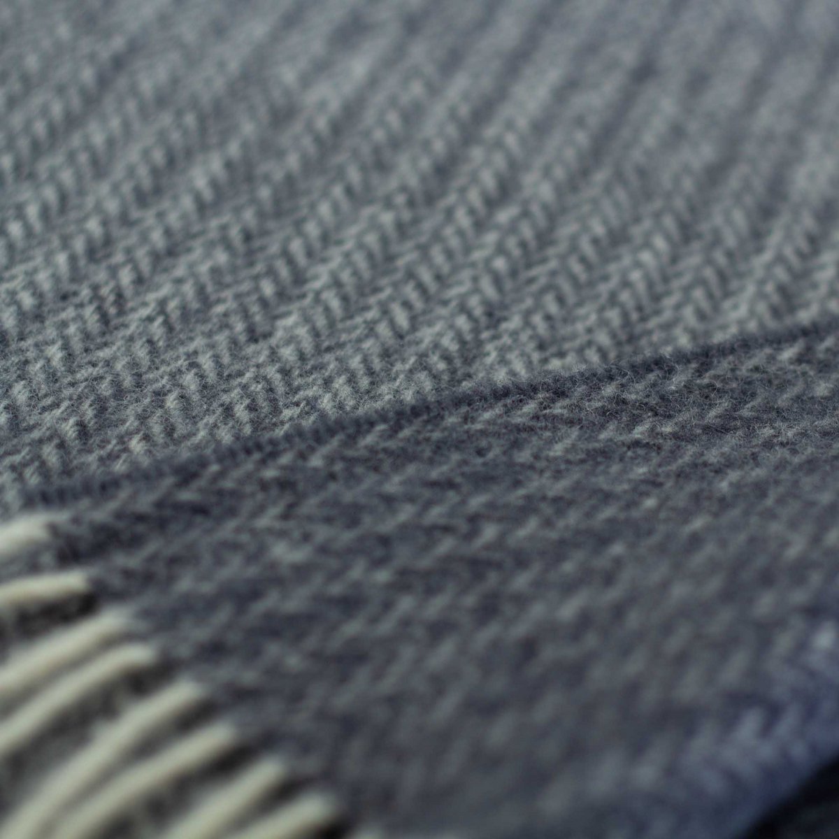 Close-up of a textured blue fabric with a herringbone pattern