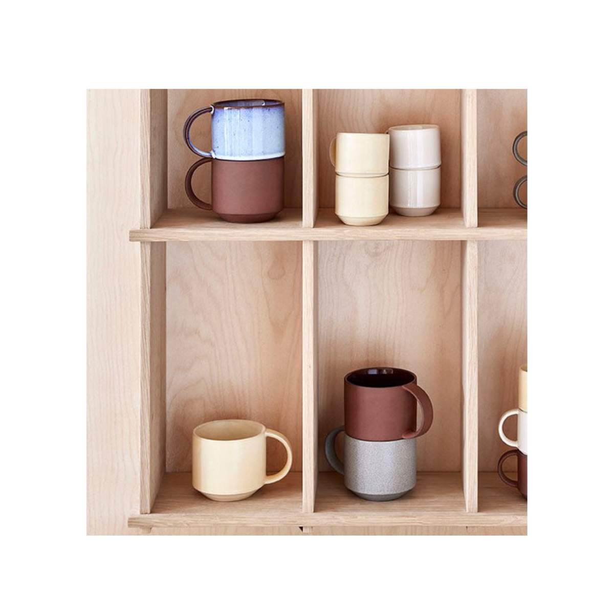 stylish designer ceramic mugs cups on wooded shelf