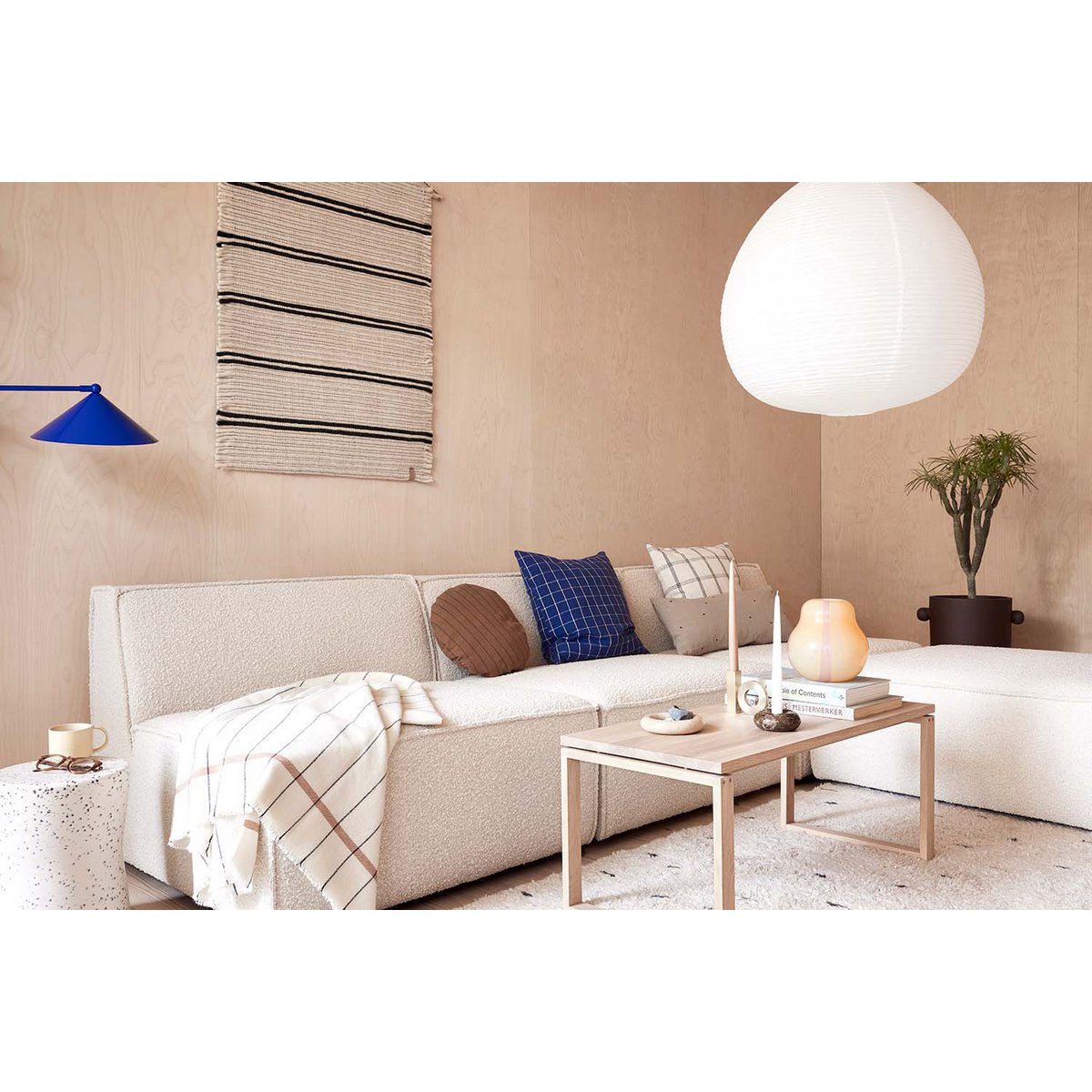 Modern living room with a beige sofa, coffee table, and decorative items including candleholders. 