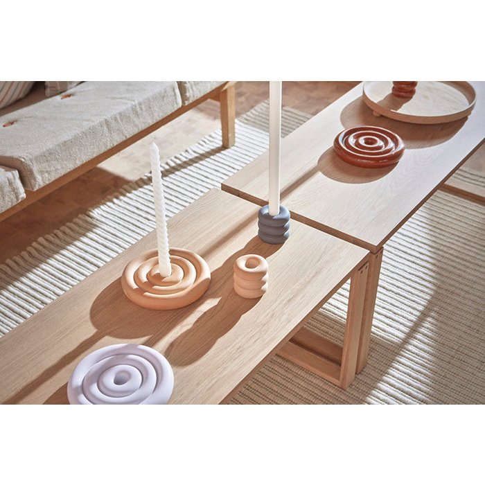 Wooden table with decorative items on a light wooden floor