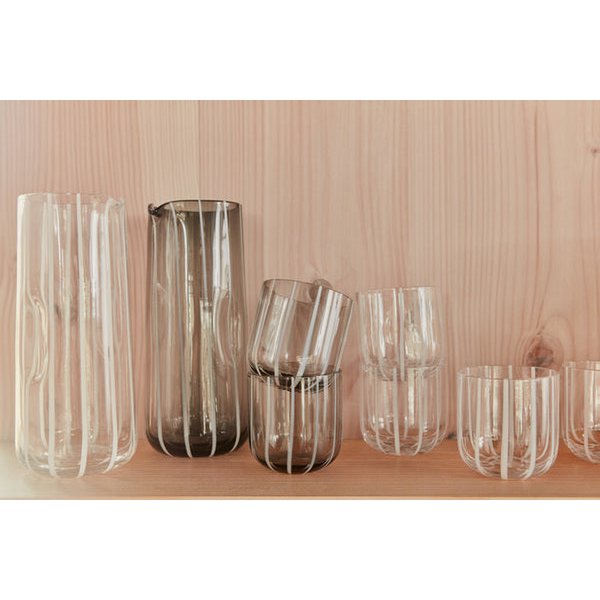 Set of clear glass vases on a wooden shelf with a wooden wall background