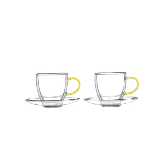 Two clear glass coffee cups with yellow handles and saucers on a white background