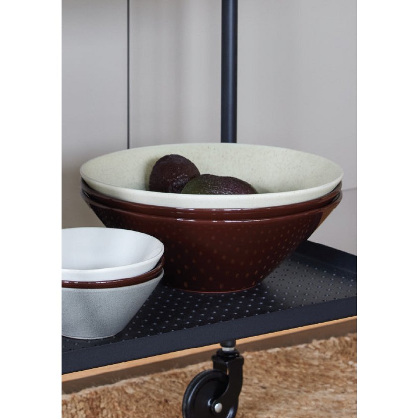 Ceramic bowls on a metal shelf with a neutral background