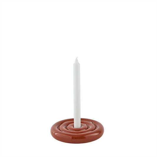 Ceramic candle holder with a white candle on a white background