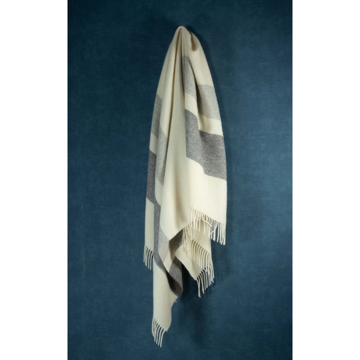 Plaid blanket with fringe on a dark blue background