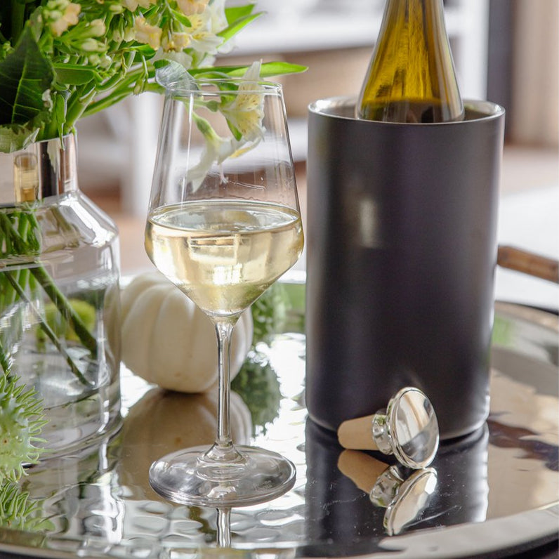 Wine bottle metal and cork stopper and bottle cooler on a silver tray. 