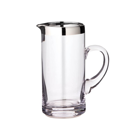 Clear glass pitcher with silver rim on a white background
