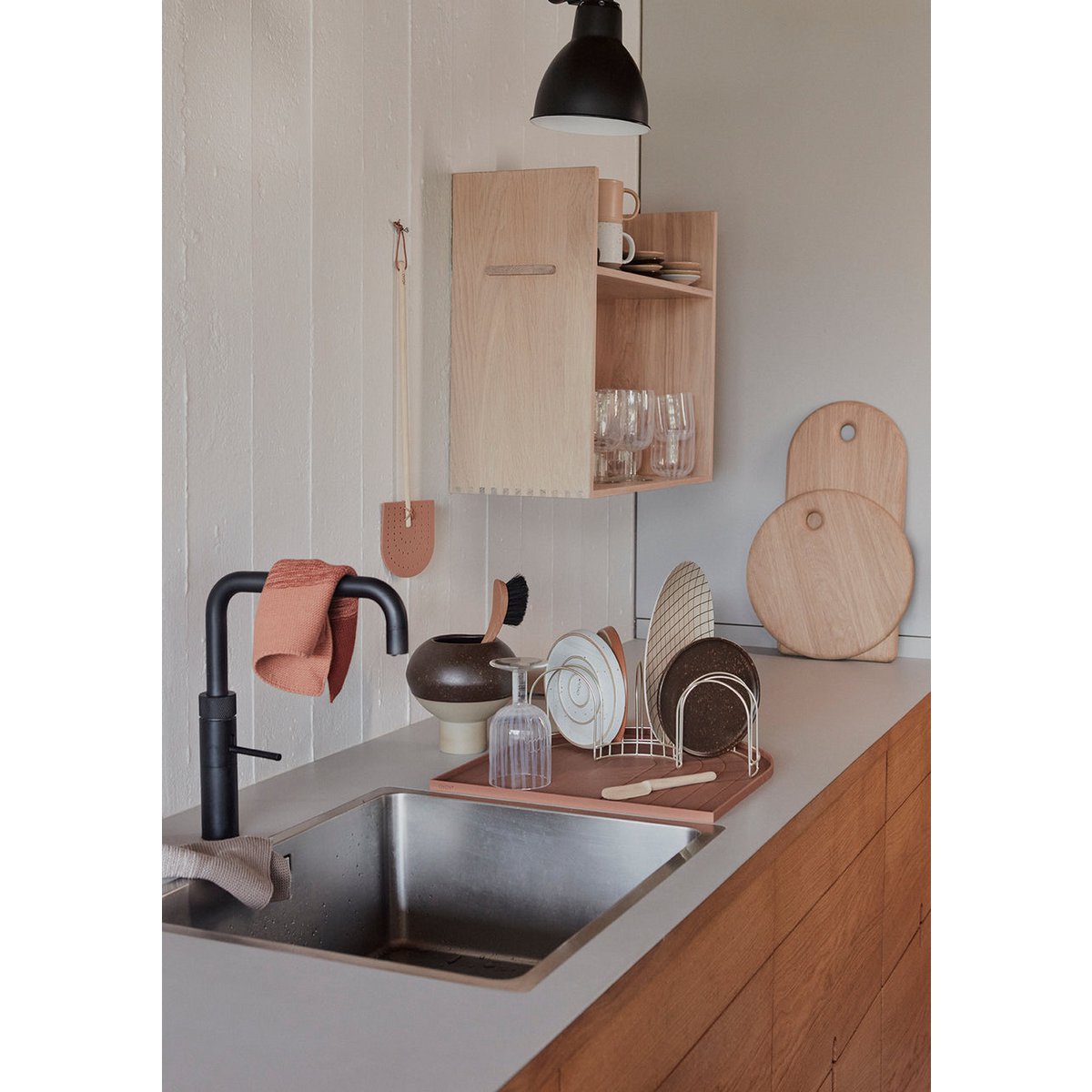 Modern kitchen with sink, wooden cabinets, and various kitchen items.