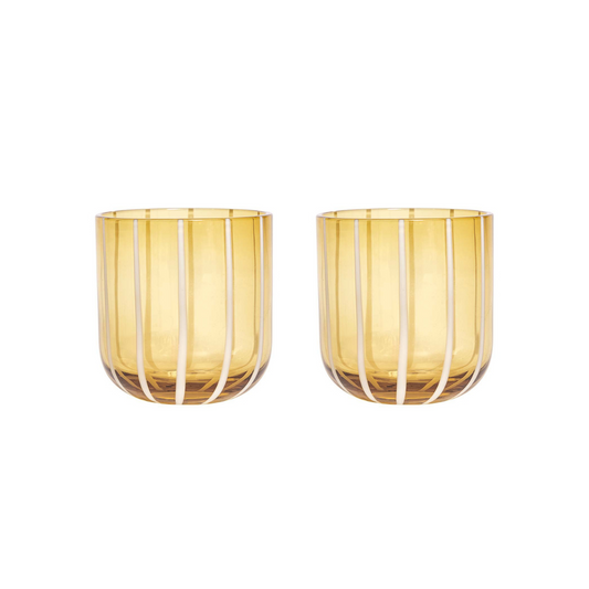 Two amber glass tumblers with white wire designs on a white background